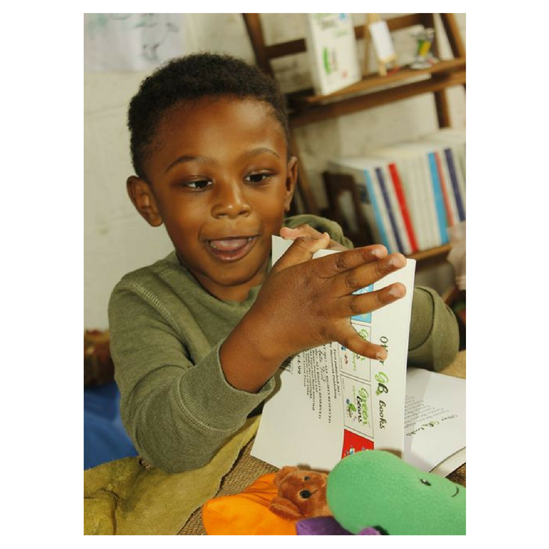 Picture of a little boy with his book with a big smile